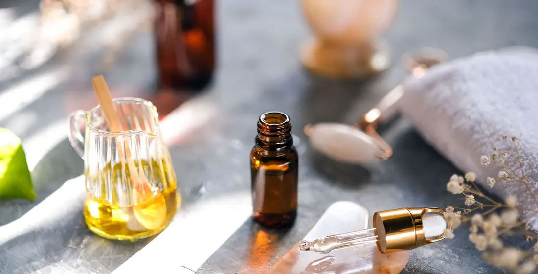 Small amber bottle of essential oil next to a glass jug of golden oil, the kind of eucalyptus oil behind the Vicks lung trick